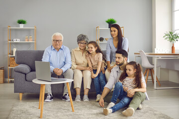 Grandparents, young couple and their daughters spend time together. Large friendly family gathered...