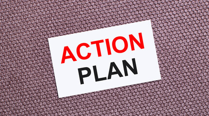 On a brown background, a white rectangular card with the text ACTION PLAN