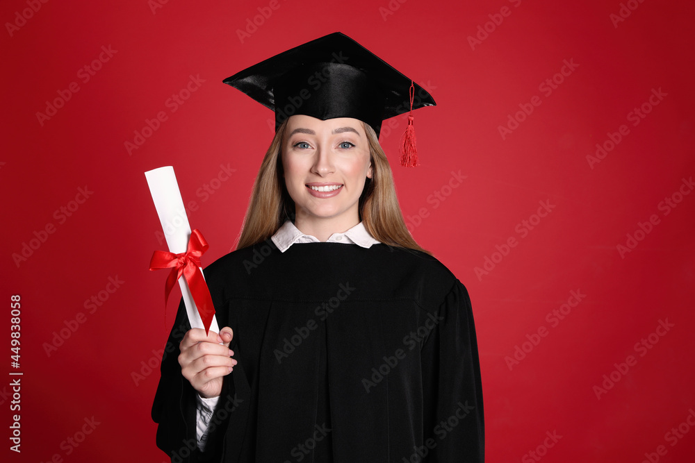 Wall mural Happy student with diploma on red background - Wall murals