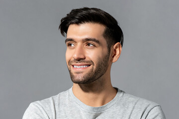 Close up portrait of happy handsome young Caucasian millennial man looking aside on isolated light gray studio background