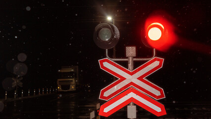 Train crossing gates closed at night. Train grade crossing with blinking or flashing lights while...