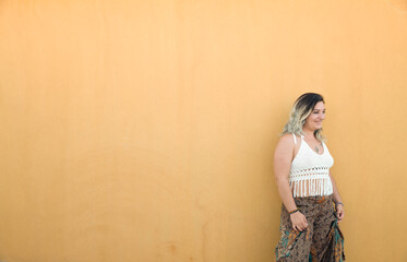Fototapeta premium Portrait of Happy Spanish girl against yellow wall