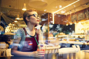 woman with short hair in a restaurant with cocktail rest drink