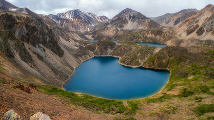 Panoramic view of a clean mountain blue lake in the shape of a heart in the Altai. Beautiful turquoise lake. Unusual transparent lake in autumn time.