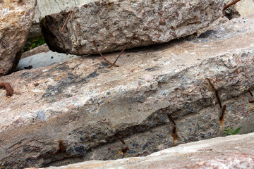 Damaged reinforced concrete blocks and slabs piled on the ground. Industrial background