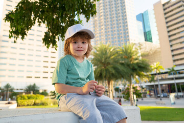 Portrait of kid outdoors on a street of Miami. Boy on city street.