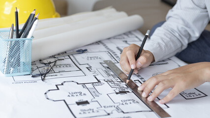 Engineer and Architect concept, Man uses a ruler to measure the floor plan on the blueprint,...