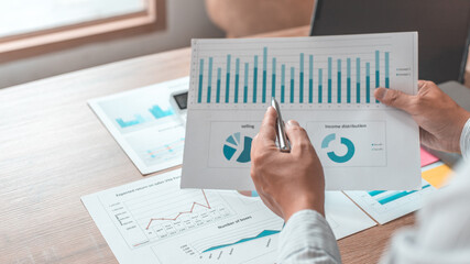 Asian businessmen are analyzing graphs, Financial statistics and calculating corporate returns in...