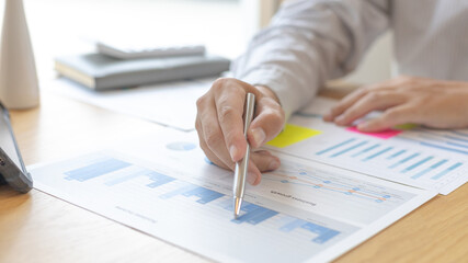 Asian businessmen are analyzing graphs, Financial statistics and calculating corporate returns in private offices, Market research reports and income statistics, Financial and Accounting concept.