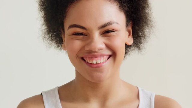 Portrait of young african american woman pulls a make face, grimacing and laughs. Sticks out one's tongue, making crazy crossed eyes have fun, fooling around making stupid brainless.