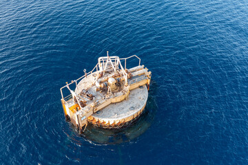 Aerial view of an abandoned offshore platform with pipelines in deep sea or ocean 