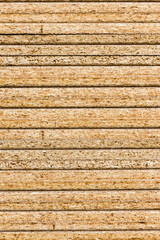 A stack of chipboard wooden panels, a smooth sawn stack, the texture of the material.