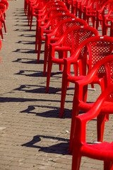 Red plastic chairs on the square.