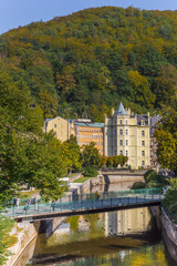 Fototapeta na wymiar Bridge over the river Tepla with historic building in the background in Karlovy Vary, Czech Republic