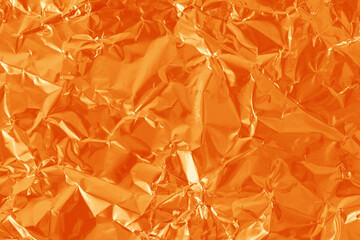 Orange color foil leaf shiny texture, abstract wrapping paper for background and design art work.
