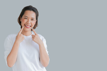close up young asian woman smiling with dental aligner retainer (invisible) isolated on gray background of dental clinic for beautiful teeth treatment course concept - obrazy, fototapety, plakaty