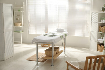 Stylish spa salon interior with massage table