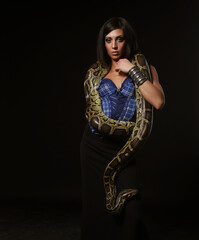 Obraz premium Young fetish woman with bright make up holding Python