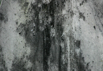 Grungy cracked and darkly stained texture of an old marble headstone