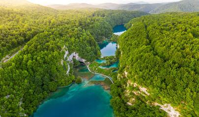 Plitvice, Croatia - Aerial panoramic view of the beautiful Plitvice Lakes (Plitvička jezera) in Plitvice National Park on a bright summer day with rising sun, summer green foliage and turquise water