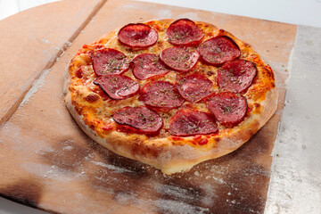 Freshly baked pizza with salami.
