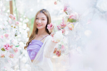 Obraz na płótnie Canvas Asian beautiful woman smiles and stands in white rose flower garden as natural , luxury theme