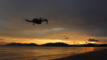 マジックアワーの夕日の瀬戸内海を飛行するドローン