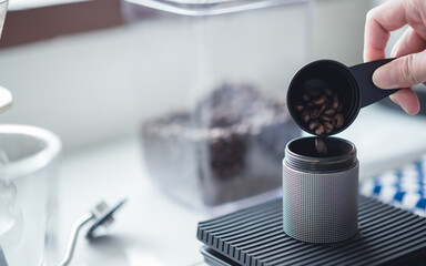 Barista women grinding coffee beans with manual grinder to making brew coffee at home. coffee drip equipment. lifestyle concept