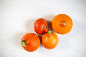 Small orange pumpkins on white wooden table
