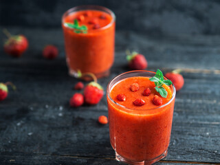 wild strawberries and strawberry smoothies in two glasses on the table
