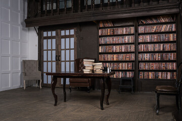 Classical library room with leather armchair, wooden table and bookcase.