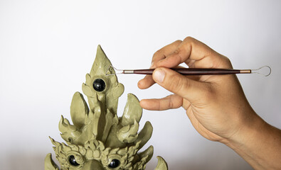 Artist creates a sculpture made of wax. by using specific sculptural tools for drawing patterns and...