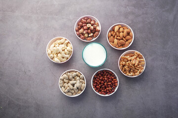 milk, peanut, hazelnut walnut , cashew nut and almond in a container on black 