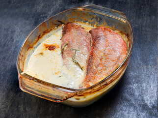 Redfish cooked in sour cream sauce in glass baking dish
