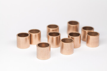 Ten sleeve bronze bearings stand on a white