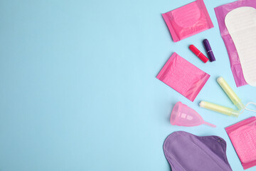 Tampons and other menstrual hygienic products on light blue background, flat lay. Space for text