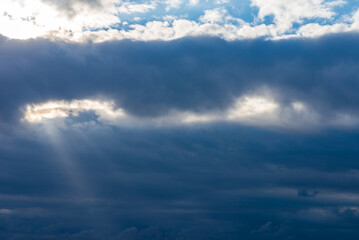 Rays of light shining throug dark clouds.Beautiful dramatic sky with sun rays.
