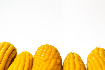 Boiled yellow sweet corn on a white background. Texture. Creative food. Swings of corn. Whole and portions of corn. Ecological food concept. Selective focus