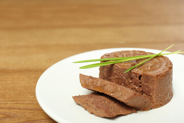 Plate with pate and grass on wooden table, closeup. Pet food - obrazy, fototapety, plakaty