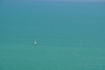 Sail boat in the distance on the sea in the morning 