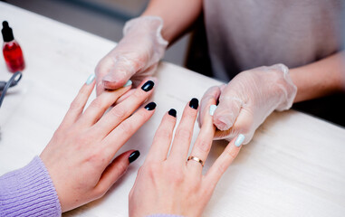 Young woman does a manicure in a nail salon. The process of a specialist's work.