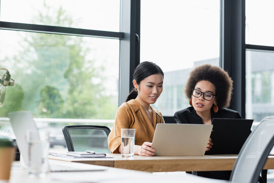 young interracial businesswomen working near laptop in office