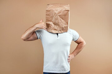 Men put a paper bag over their heads, pretending to ring a non-existent phone. Isolated on yellow...