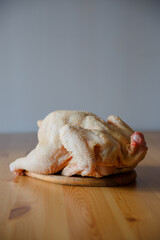 Fototapeta na wymiar Domestic chicken, farm meat. Photo of a cut chicken without feathers on a wooden table