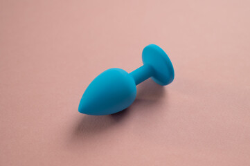 Blue anal plug on a pink background. Adult toy for alternative sex