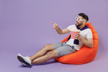Full size body young brunet man 20 in 3d glasses wear white t-shirt purple shirt sit in bag chair...