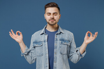 Spiritual tranquil attractive fun young brunet man 20s wears denim jacket hold spreading hands in...