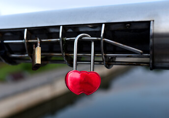 Padlock on Lovers Lock Bridge. Husband and wife during the wedding hung a padlock on the fence on metal grate. Love locks concept. Many a padlock are locked with a key for the happiness of people