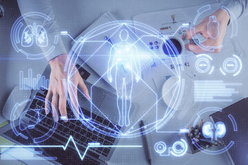Double exposure of man's hands typing over computer keyboard and science theme hologram drawing. Top view. Education concept.