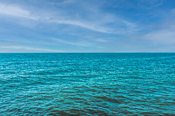 Obraz premium Beautiful turquoise sea water against the blue sky. View from a tropical beach. Summer sunny day, rest.